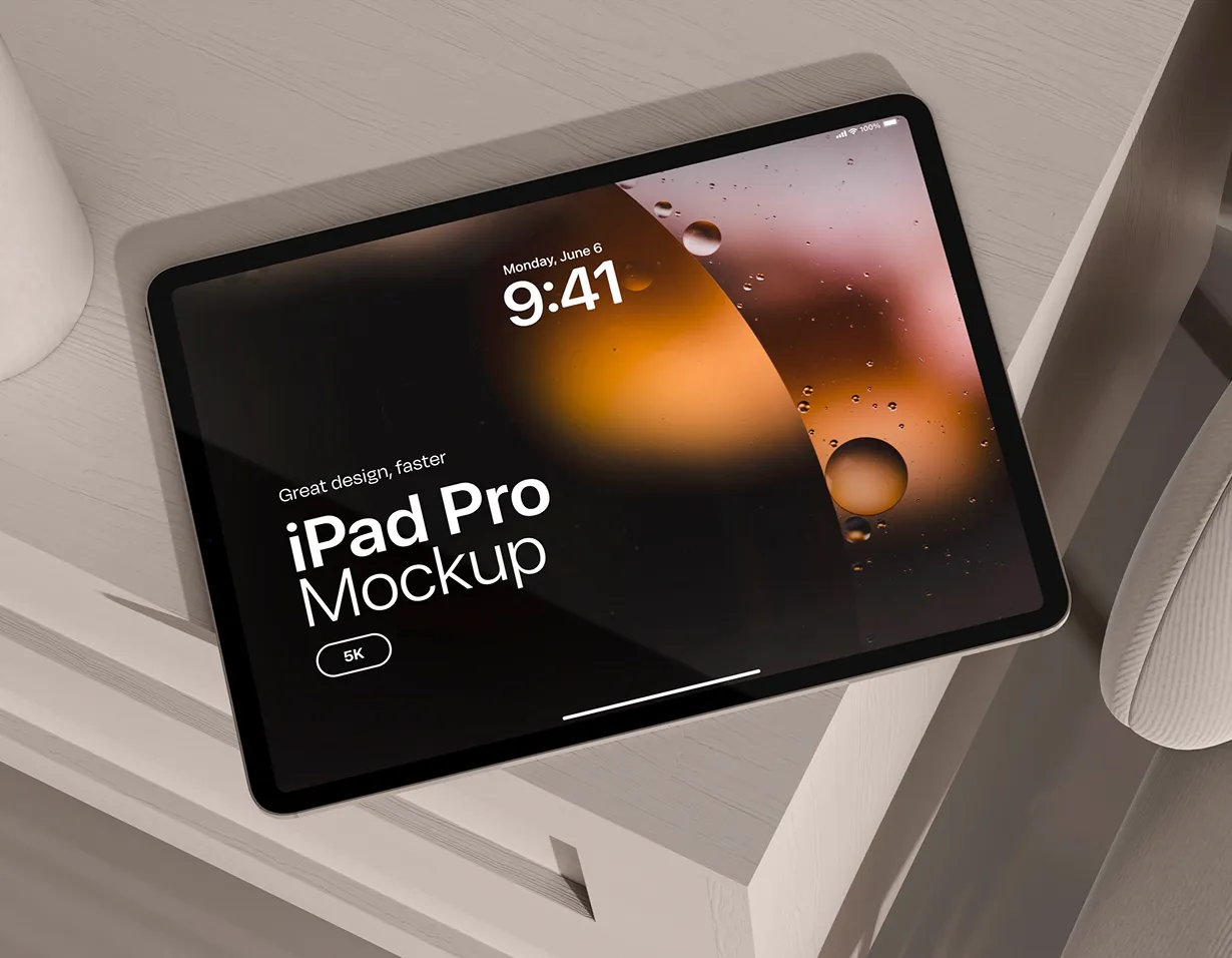 Black iPad Pro lying on a table showing a dark lock-screen mockup.