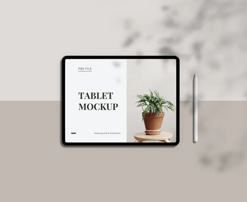 Tablet mockup with plant and blurred background design on beige and white surface.
